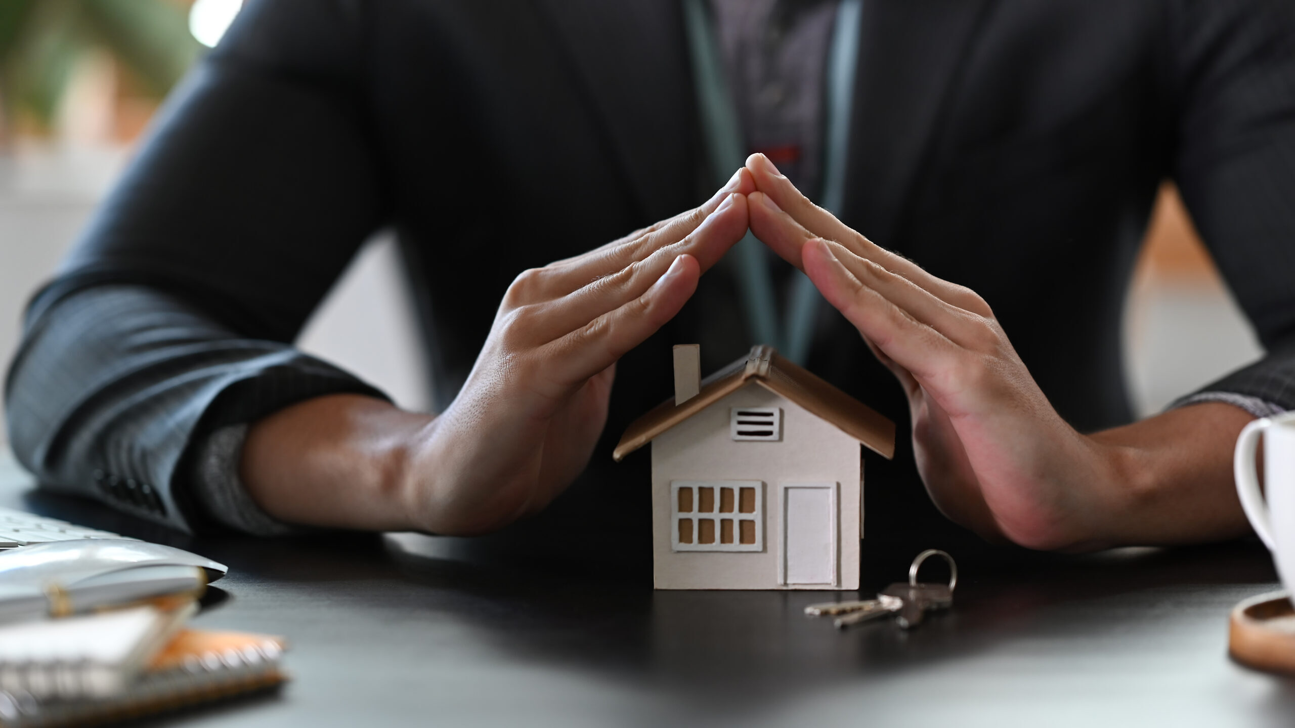 Estate agent hands over house model for protection and care. Pro Makler