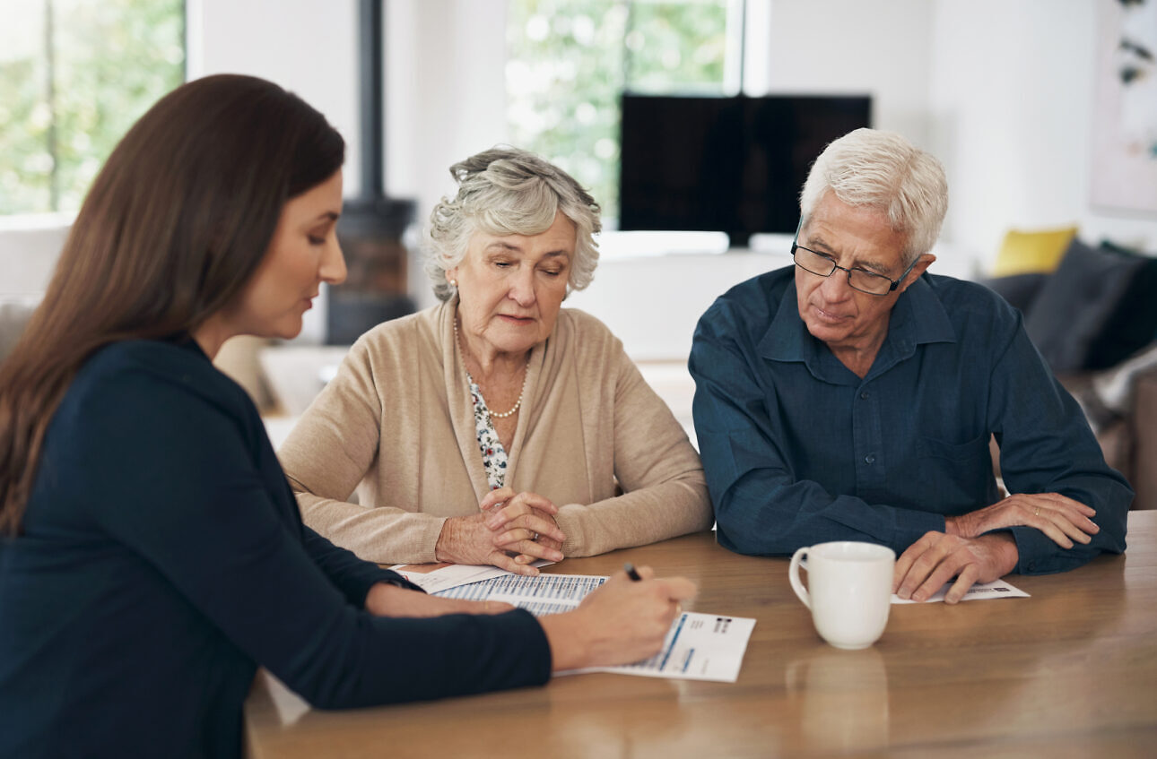 Investment, senior couple and meeting with a financial advisor, lawyer or woman consulting on a contract, loan or deal. Signing, documents and people with a mortgage, debt or saving in retirement Sale and lease back