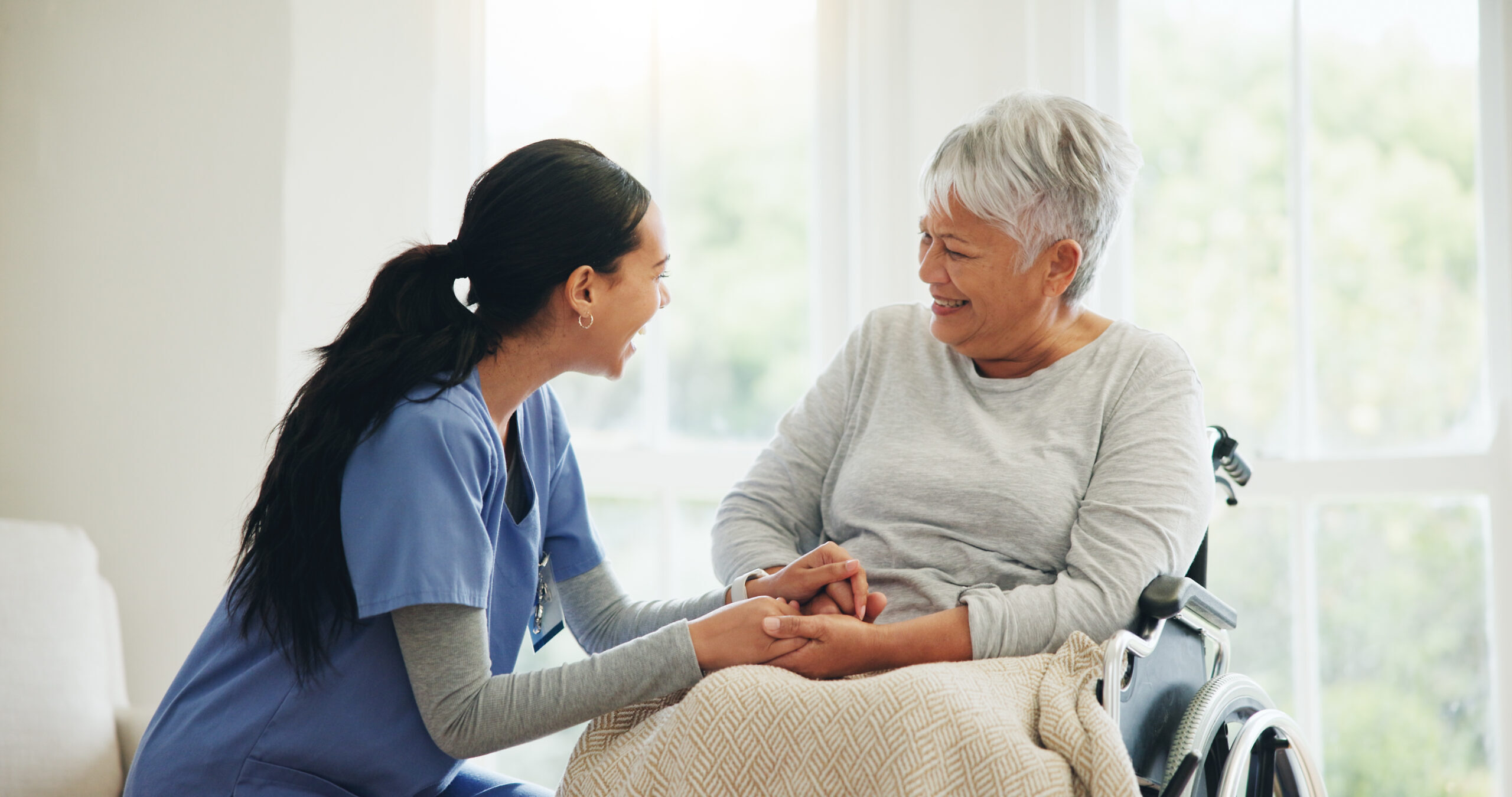 Happy woman, doctor and holding hands with senior patient in wheelchair, support or trust for healthcare at home. Medical nurse, caregiver or person with a disability smile for care or help at house Pflegeimmobilien