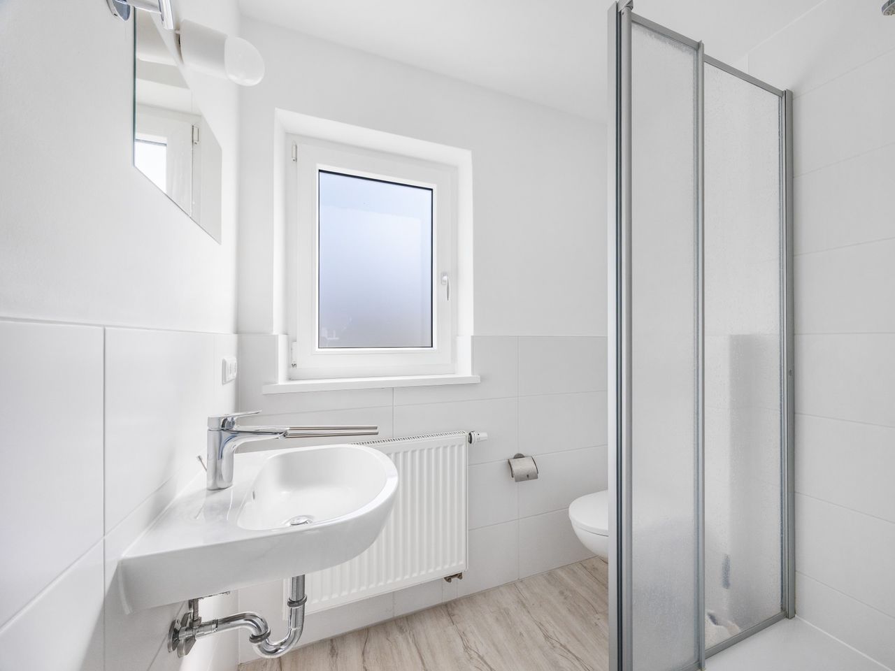 Badezimmer mit Dusche und Fenster