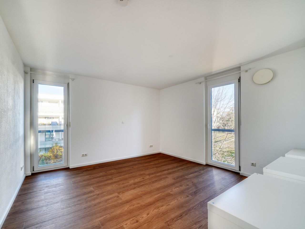 Quadratisch geschnittenes Schlafzimmer mit bodentiefen Fenstern